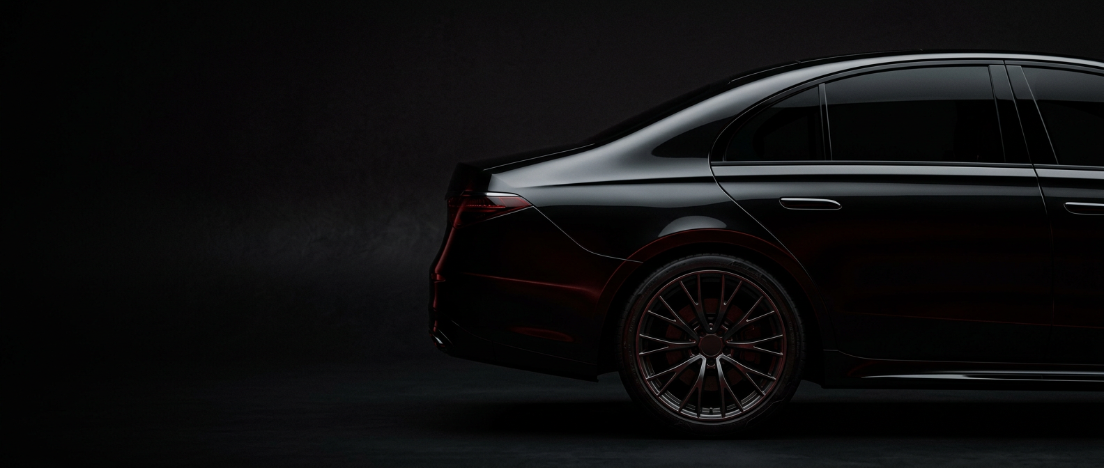Detalle lateral de una berlina negra en un estudio oscuro con reflejos rojos